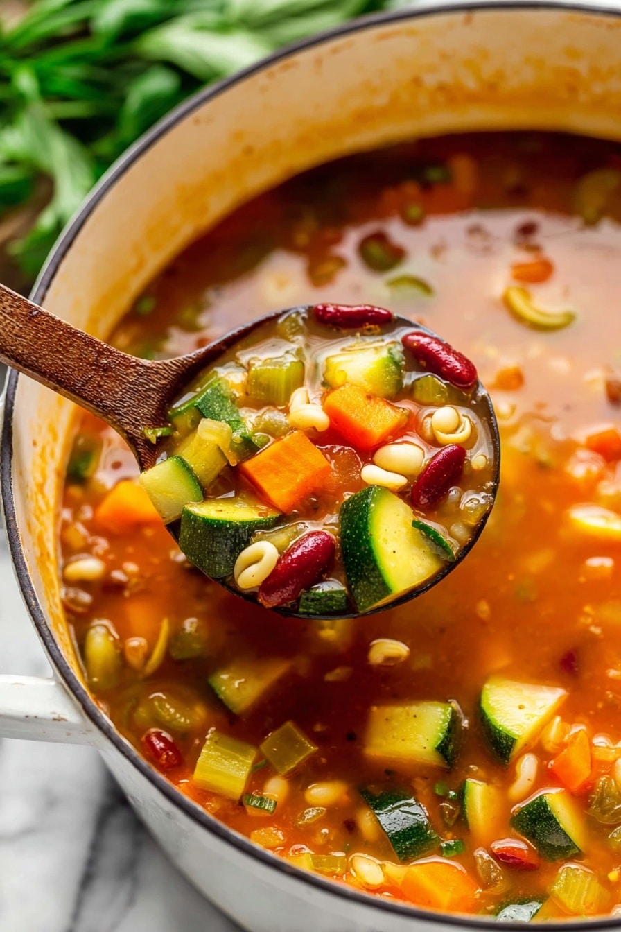 A white pot filled with a thick stew showing layers of diced yellow and green zucchini, orange carrot pieces, red beans, chickpeas, shell pasta, and small red tomato chunks mixed in a rich orange-red broth with herbs, placed on a white marbled surface. A black spoon is inside the pot, and nearby are bunches of fresh green parsley, a gray and white striped cloth, and two silver spoons. Photo taken with an iphone --ar 2:3 --v 7
